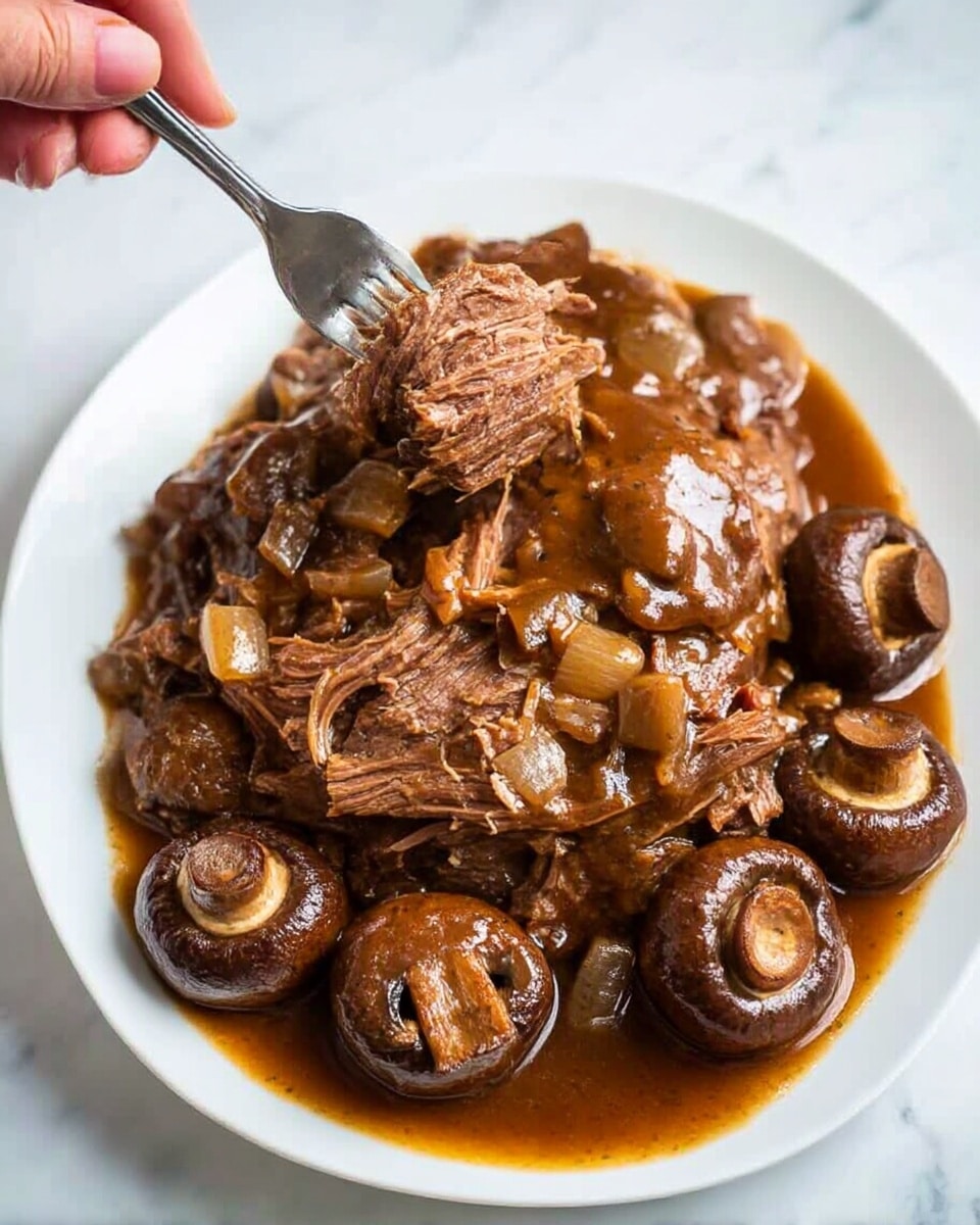 A white plate holds a serving of shredded brown meat covered in a thick, glossy brown sauce with small pieces of mushroom and onion scattered all over. The meat is falling apart and being gently pulled by a silver fork held by a woman's hand from the top left, showing tender texture. Whole brown mushrooms surround the meat on the lower right side, all resting on a pool of the rich sauce. The dish is placed on a white marbled surface with bright light highlighting the glossy texture of the sauce and the meat's fibrous layers. photo taken with an iphone --ar 4:5 --v 6.1