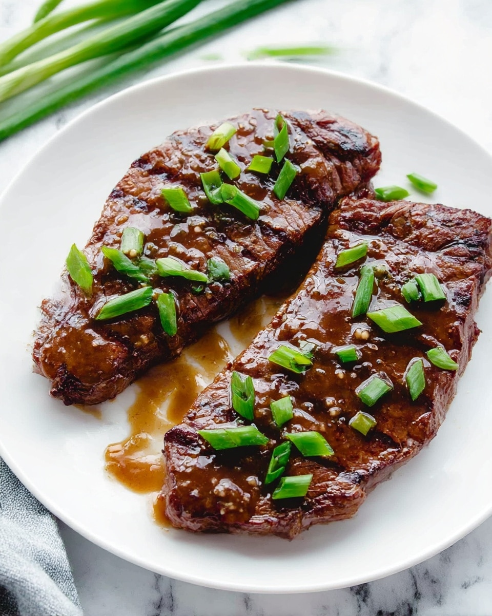 Two cooked steaks with dark brown grill marks are placed side by side on a white plate. The steaks have a glossy brown sauce drizzled over them, creating a shiny texture. Scattered on top and around the steaks are small pieces of fresh green onion, adding a pop of bright green color. The plate is set on a white marbled surface, and some green onions are visible blurred in the background. The overall look is simple and fresh with a focus on the juicy grilled meat. photo taken with an iphone --ar 4:5 --v 7
