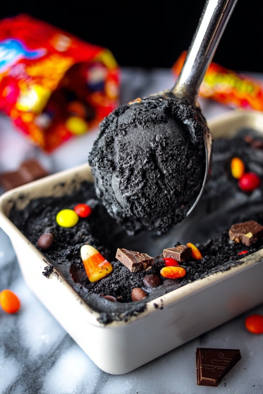 Boo Batter No-Churn Ice Cream with Kit Kats and Halloween Colors, Halloween ice cream recipes, no-churn fall desserts, spooky Halloween dessert ideas, easy Halloween ice cream - The image shows a scoop of dark black ice cream with a rough texture lifted on a metal ice cream scooper above a white dish filled with the same ice cream. The ice cream base is very dark, almost charcoal black, with visible chunks mixed inside. Around the edges of the dish, colorful candy pieces like red, yellow, orange, and white candy-coated chocolates and pieces of chocolate bars are scattered. In the background, there is a colorful, open candy bag lying on a white marbled surface. The scene has a close-up focus on the dark ice cream. photo taken with an iphone --ar 2:3 --v 7