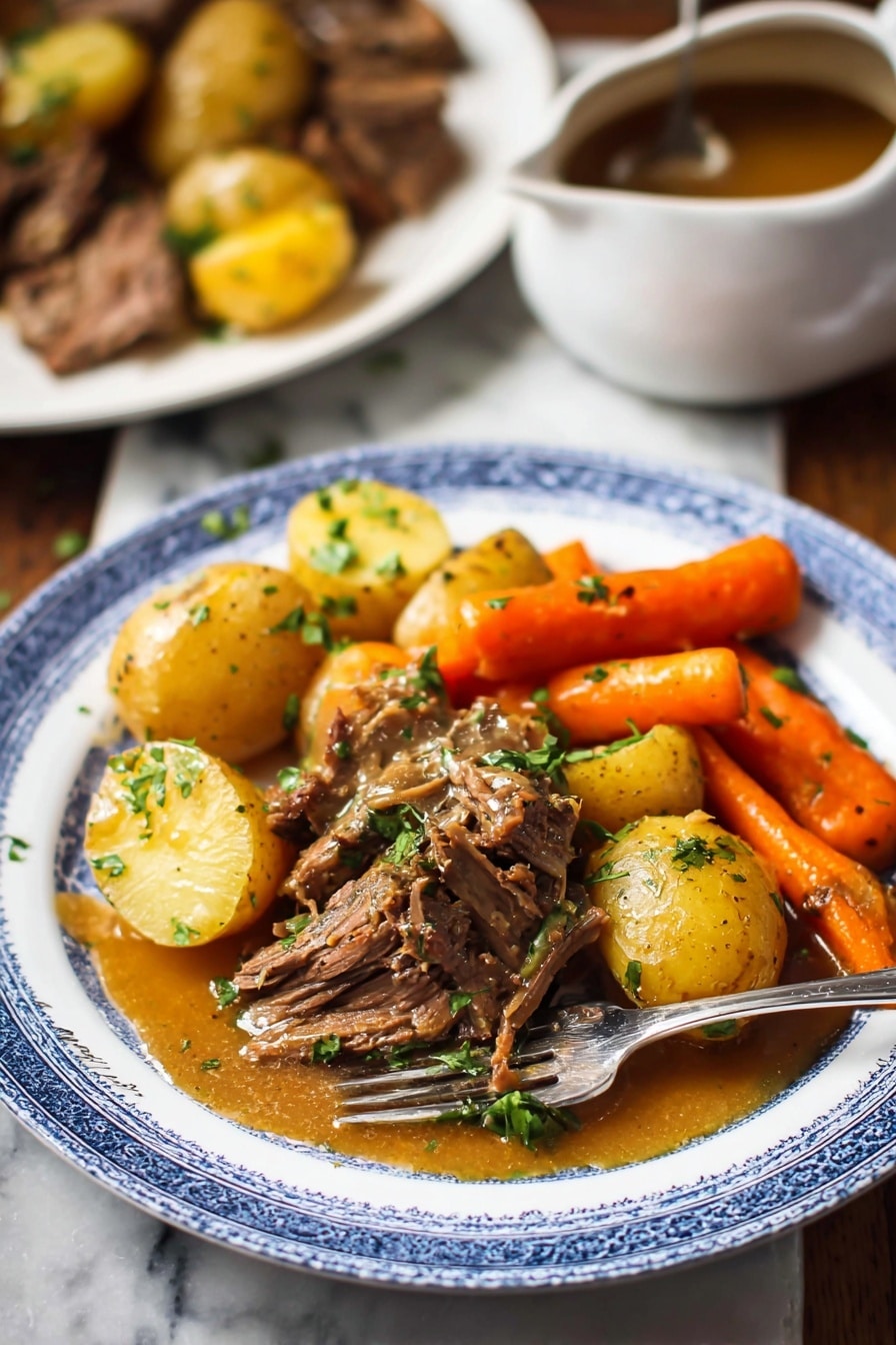 Slow Cooker Pot Roast with Root Vegetables and Herb Gravy, hearty beef stew, easy slow cooker dinner, cozy family meal, flavorful roast with vegetables - A white plate with a blue rim holds a hearty meal featuring three main layers: golden brown pieces of cooked beef in the center topped with chopped green herbs, tender yellow baby potatoes scattered around the beef, and bright orange carrot sticks positioned near the back. A golden brown sauce with a smooth texture lightly covers parts of the beef and potatoes. A silver fork rests on the plate's edge. In the background, there is a white marbled surface with a blurred white plate containing more beef and potatoes, and a white saucepan with brown sauce on the left side. The overall scene has warm, natural lighting. photo taken with an iphone --ar 2:3 --v 7