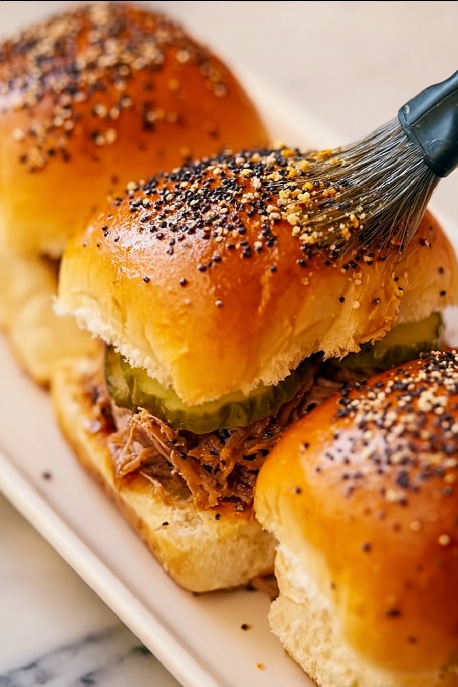 Cheesy Pulled Pork Cuban Sliders, pulled pork sliders recipe, Cuban sliders with cheese, easy pulled pork sliders, flavorful slider sandwiches - The image shows a close-up of a golden brown bread roll cluster with a shiny surface, sprinkled with white sesame seeds and black poppy seeds. There is a yellow silicone brush with black details gently spreading a glaze on the soft tops of the rolls. The bread rolls appear fluffy and slightly puffy, with visible seams and light texture. The background is a white marbled surface. photo taken with an iphone --ar 2:3 --v 7