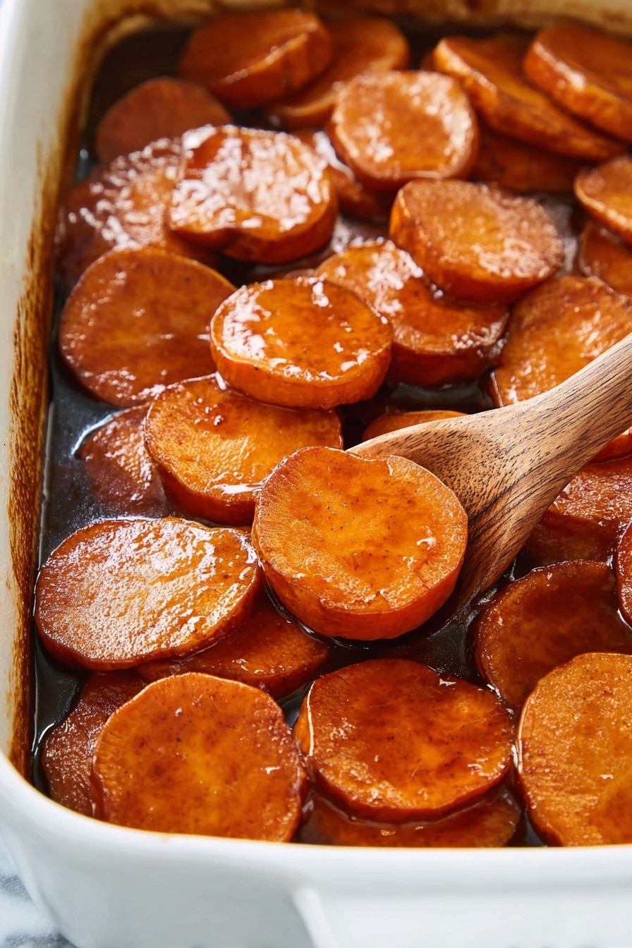 Southern Candied Yams, Soul Food Yams, Candied Yams Recipe, Sweet Potato Side Dish, Holiday Yams - The image shows a close-up of a white baking dish filled with thick, round slices of sweet potatoes, cooked in a rich, shiny brown glaze that coats each slice with a sticky texture. The sweet potato slices are arranged in a slightly overlapping layer, showing their smooth and glossy surface with a warm orange-brown color. A wooden spoon is partially visible on the right side, scooping some slices, adding a natural wooden texture to the scene. The background and surface are a white marbled texture. photo taken with an iphone --ar 2:3 --v 7