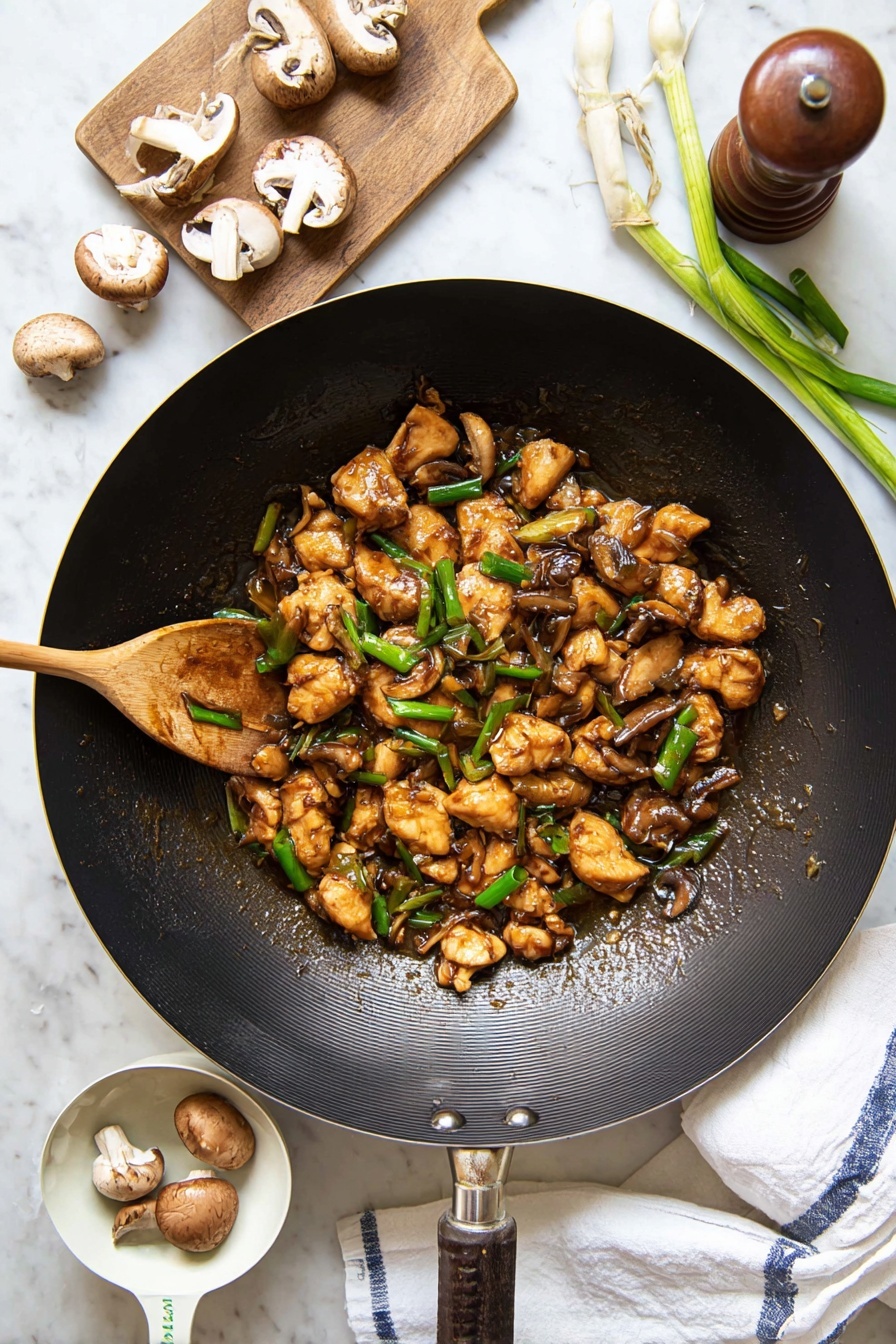 Black Pepper Mushroom Chicken Stir Fry, easy stir fry recipes, healthy chicken stir fry, mushroom chicken dinner, quick Asian stir fry - A large black wok filled with several small pieces of golden-brown cooked chicken mixed with sliced brown mushrooms and bright green chopped spring onions, all coated in a glossy brown sauce. A wooden spoon stirs the mixture from the left side of the wok. Around the wok, there are whole and sliced mushrooms, a wooden pepper grinder, fresh green spring onions on a small wooden board, and a white measuring cup holding two mushrooms. The entire scene is set on a white marbled surface with a white cloth towel showing blue stripes placed under the wok’s handle. photo taken with an iphone --ar 2:3 --v 7