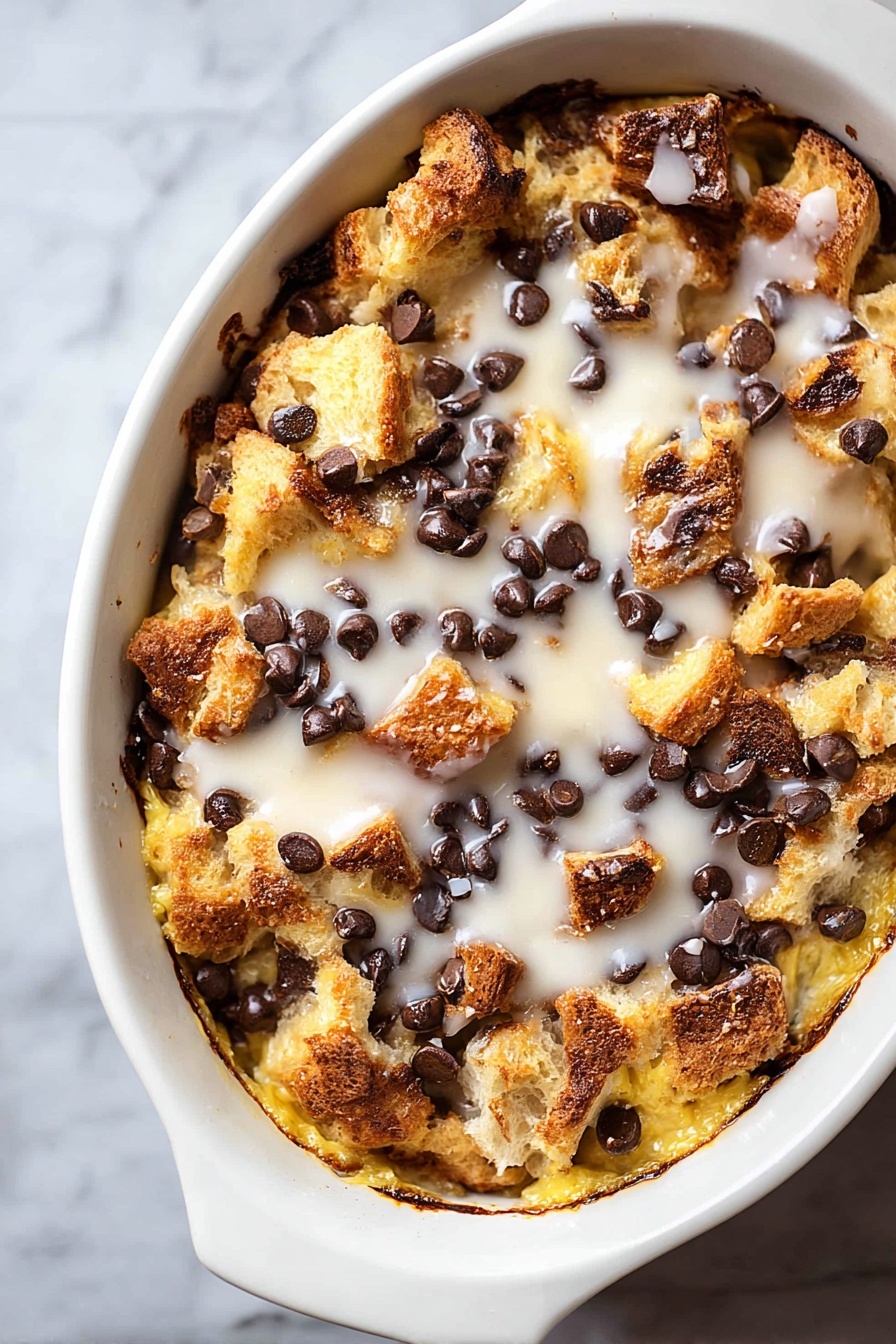 Tres Leches Bread Pudding with Chocolate Chips, Tres Leches Bread Pudding, Chocolate Chip Dessert, Milk-Soaked Bread Pudding, Easy Tres Leches Dessert - A white oval dish filled with a baked dessert featuring a rough top layer of golden brown bread chunks mixed with melted dark chocolate chips scattered evenly. Below this, a creamy, slightly crispy, yellow layer is visible, soaked with a white glaze drizzled across the top, adding a shiny texture. The edges of the dish show browned and slightly caramelized spots, giving a crunchy look to the dessert. The dish rests on a white marbled surface. photo taken with an iphone --ar 2:3 --v 7