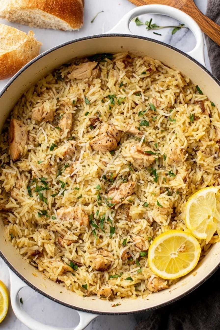 Lemon Chicken and Orzo, lemon chicken skillet, lemon chicken dinner, one-pan chicken and orzo, easy lemon chicken recipe - A white pot filled to the top with cooked yellowish rice mixed with small pieces of light-brown cooked chicken, scattered with thin green herb leaves and a sprinkle of grated cheese or seasoning on top, with two thin lemon slices resting near the edge of the pot. The pot is placed on a white marbled surface with a piece of bread in the top left corner and a woman's hand in the lower left corner holding a utensil. photo taken with an iphone --ar 2:3 --v 7