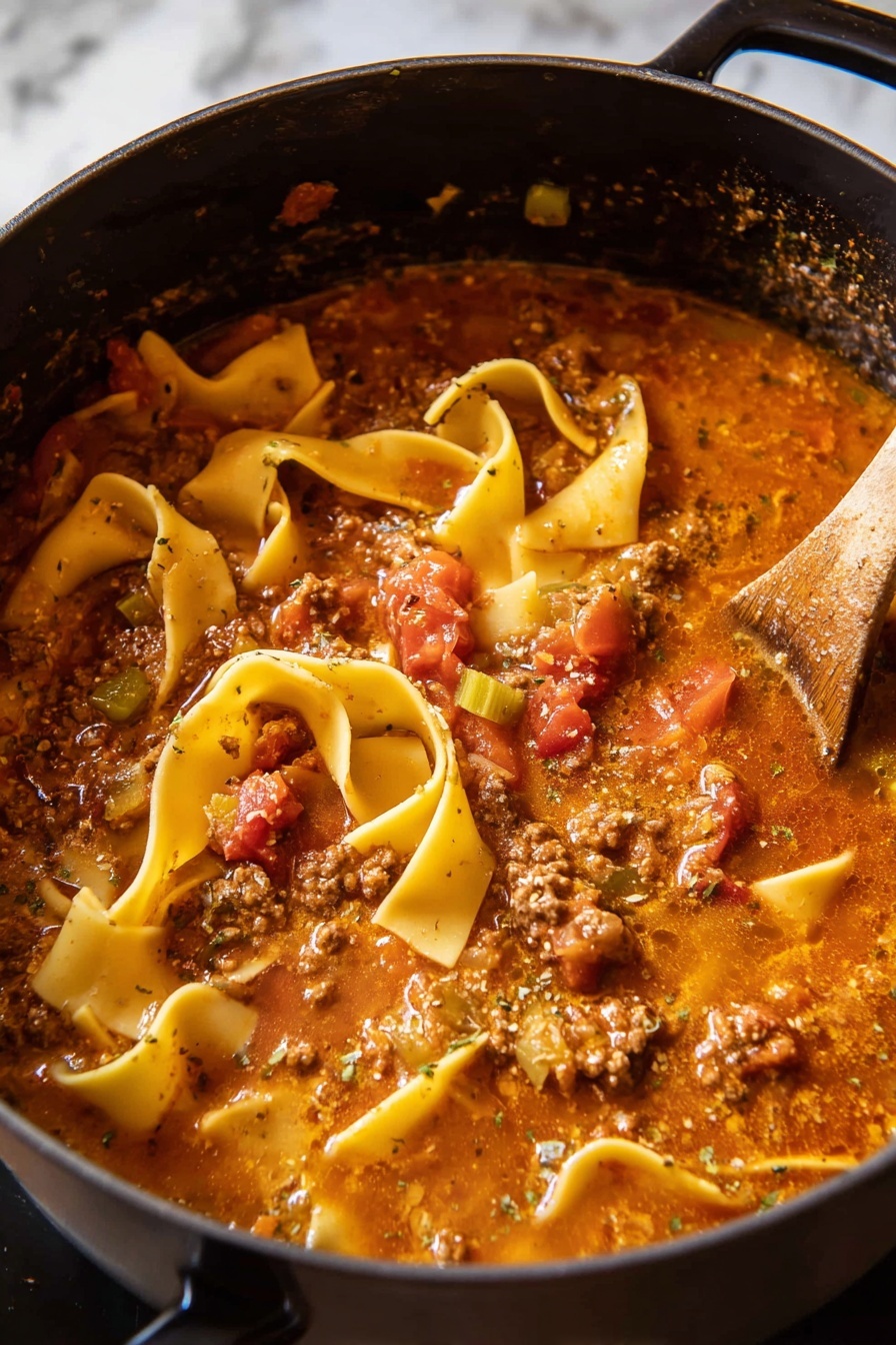 Spicy Lasagna Soup, lasagna soup recipe, comfort food soup, quick lasagna dinner, cheesy spicy soup - A black pot filled with thick lasagna soup showing several wide, flat, yellow pasta sheets, some curled and some straight, floating on a rich, chunky tomato-based broth with visible pieces of ground meat, diced red tomatoes, and bits of green celery. The soup has a slightly oily, speckled surface with herbs and spices, and steam rises gently from the hot mixture. A wooden spoon is partly submerged on the right side, stirring the soup. The pot is positioned against a white marbled background. photo taken with an iphone --ar 2:3 --v 7