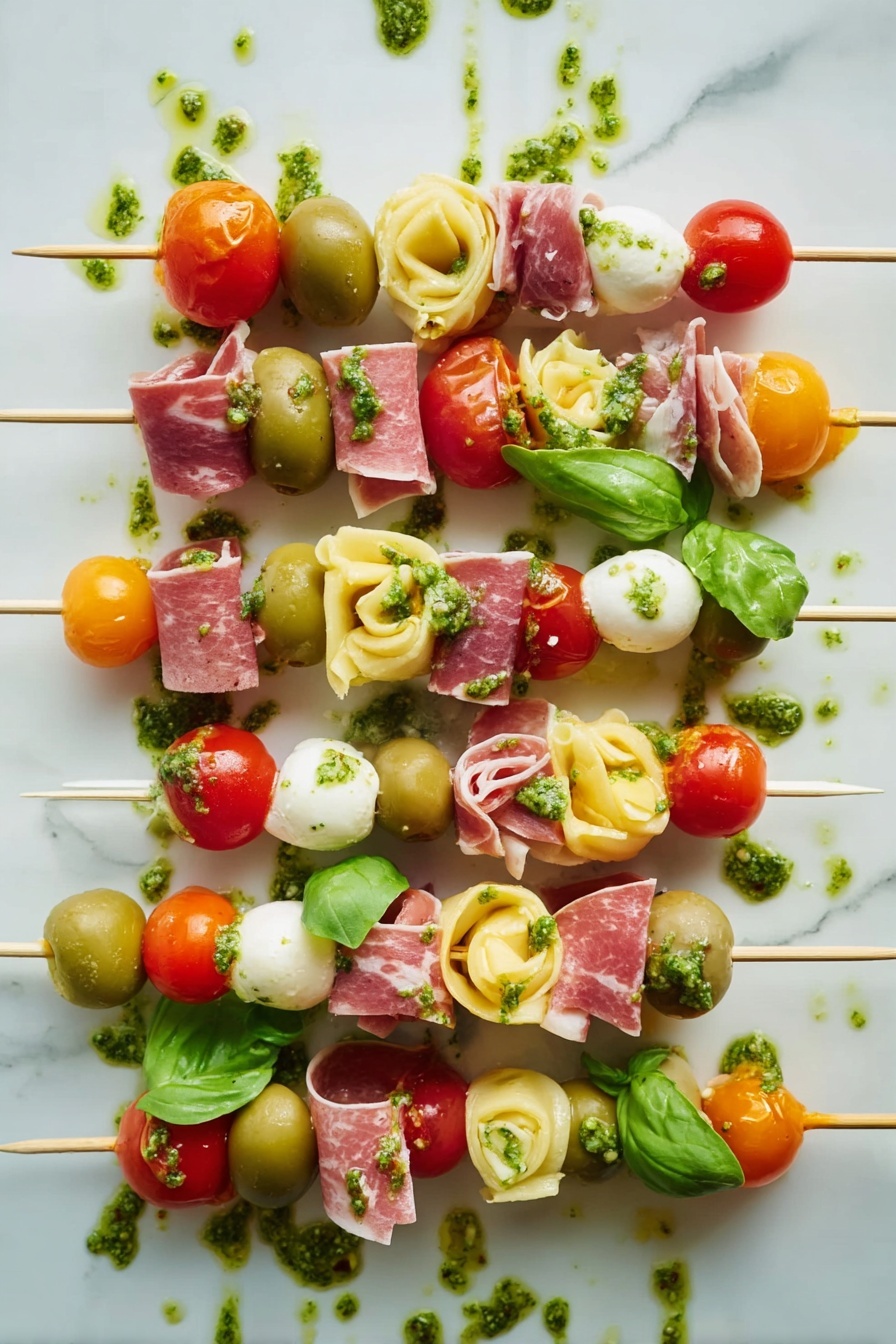 Antipasto Skewers with Tortellini and Cheese, easy antipasto appetizer, party appetizer recipes, skewered antipasto platter, savory appetizer ideas - The image shows several skewers with five to seven layers each, arranged side by side on a white marbled surface. Each skewer has colorful ingredients stacked in this order from top to bottom: red cherry tomatoes or orange cherry tomatoes, green basil leaves or whole green olives, light yellow tortellini pasta, thin swirled slices of pink cured meat, and white cheese cubes or white mozzarella balls. Some layers also have small pieces of bright red roasted pepper. Green pesto sauce is drizzled over the skewers and on the surface around them, adding an extra texture and shine to the image. The overall look is fresh, vibrant, and neatly arranged. photo taken with an iphone --ar 2:3 --v 7