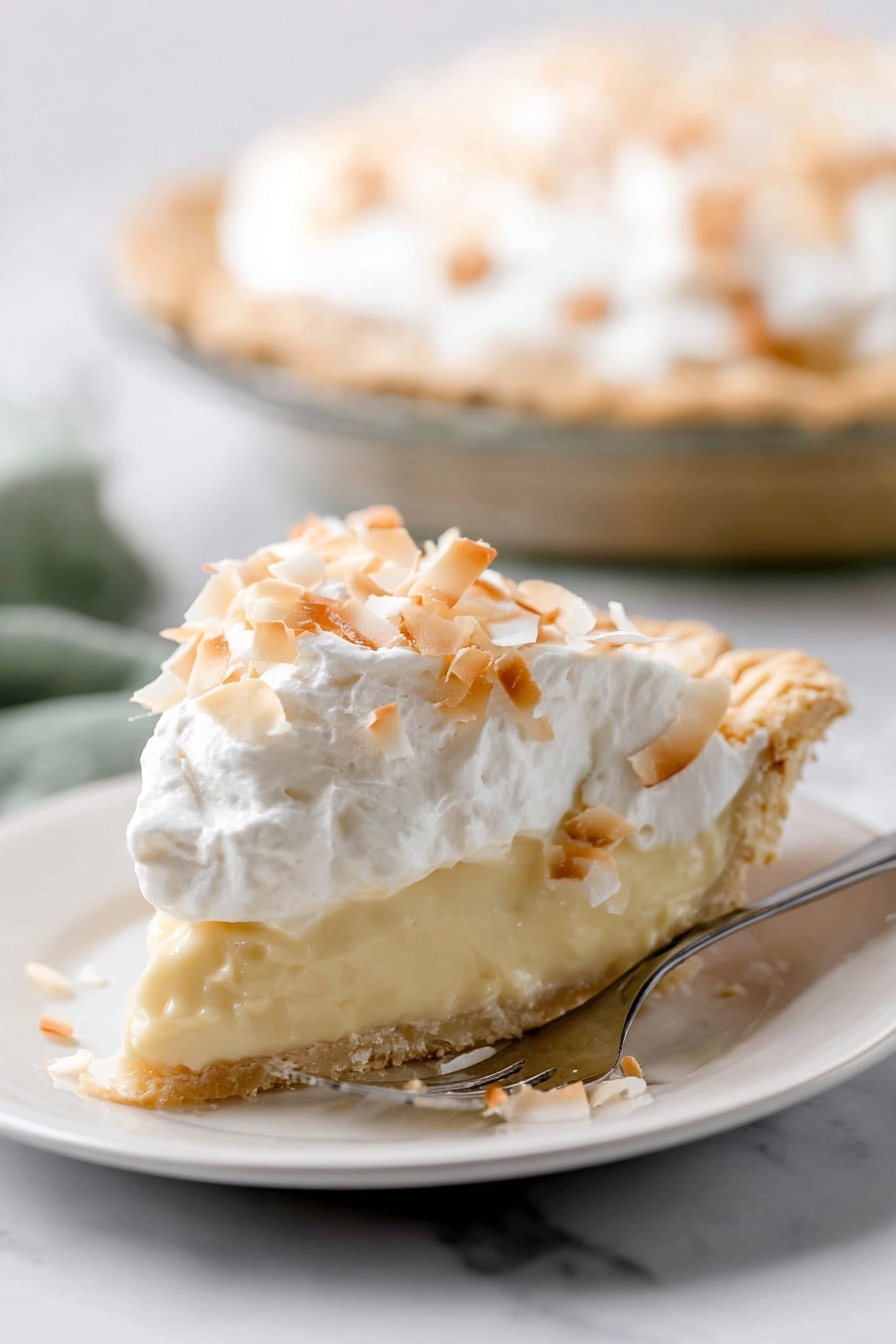Homemade Coconut Cream Pie, coconut cream pie, tropical dessert, easy coconut pie, homemade pie recipe - A slice of pie is shown on a white plate, with three clear layers. The bottom layer is a light golden crust with a slightly crumbly texture. The middle layer is thick and creamy, pale yellow in color, smooth and soft looking. The top layer is white whipped cream, fluffy, covered with toasted coconut flakes that are light brown and white, scattered unevenly. The pie is on a white marbled surface, and in the background, the rest of the pie is visible in a clear pie dish. A silver fork with text is placed beside the slice on the plate. photo taken with an iphone --ar 2:3 --v 7