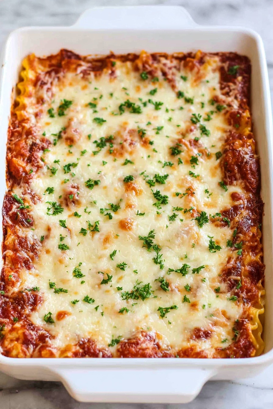 Cheesy Beef Lasagna Roll-Ups, lasagna roll-ups recipe, easy cheesy beef dinner, family-friendly lasagna, comfort food ideas - A white rectangular baking dish filled with a layered lasagna. The top layer is melted cheese with golden brown spots and sprinkled with small green parsley pieces. The layer underneath shows hints of a rich red tomato sauce and pasta edges peeking through. The dish is placed on a white marbled surface. photo taken with an iphone --ar 2:3 --v 7