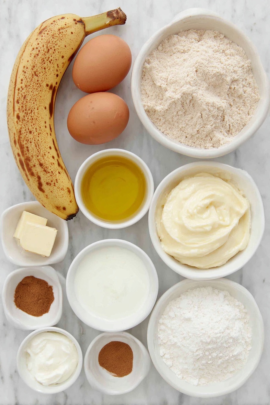 Whole Wheat Banana Bread with Cinnamon Crumble, healthy banana bread, healthy banana bread, moist banana bread, cinnamon crumble banana bread - Flat lay of two large brown eggs with clean shells, a small bunch of ripe bananas with brown spots (one peeled showing mashed texture), a small white ceramic bowl of light golden oil, a small white bowl of creamy Greek yogurt, a small white bowl filled with whole wheat flour, a small white bowl of fine white cornstarch, a small white bowl of ground cinnamon powder, a small white bowl of light brown sugar, a small white bowl of soft pale butter, and a small white bowl of fine salt crystals, all ingredients arranged symmetrically in simple white ceramic bowls and plates, placed on a clean white marble surface, soft natural light, photo taken with an iPhone, professional food photography style, fresh ingredients, white ceramic bowls, no bottles, no duplicates, no utensils, no packaging --ar 2:3 --v 7 --p m7354615311229779997